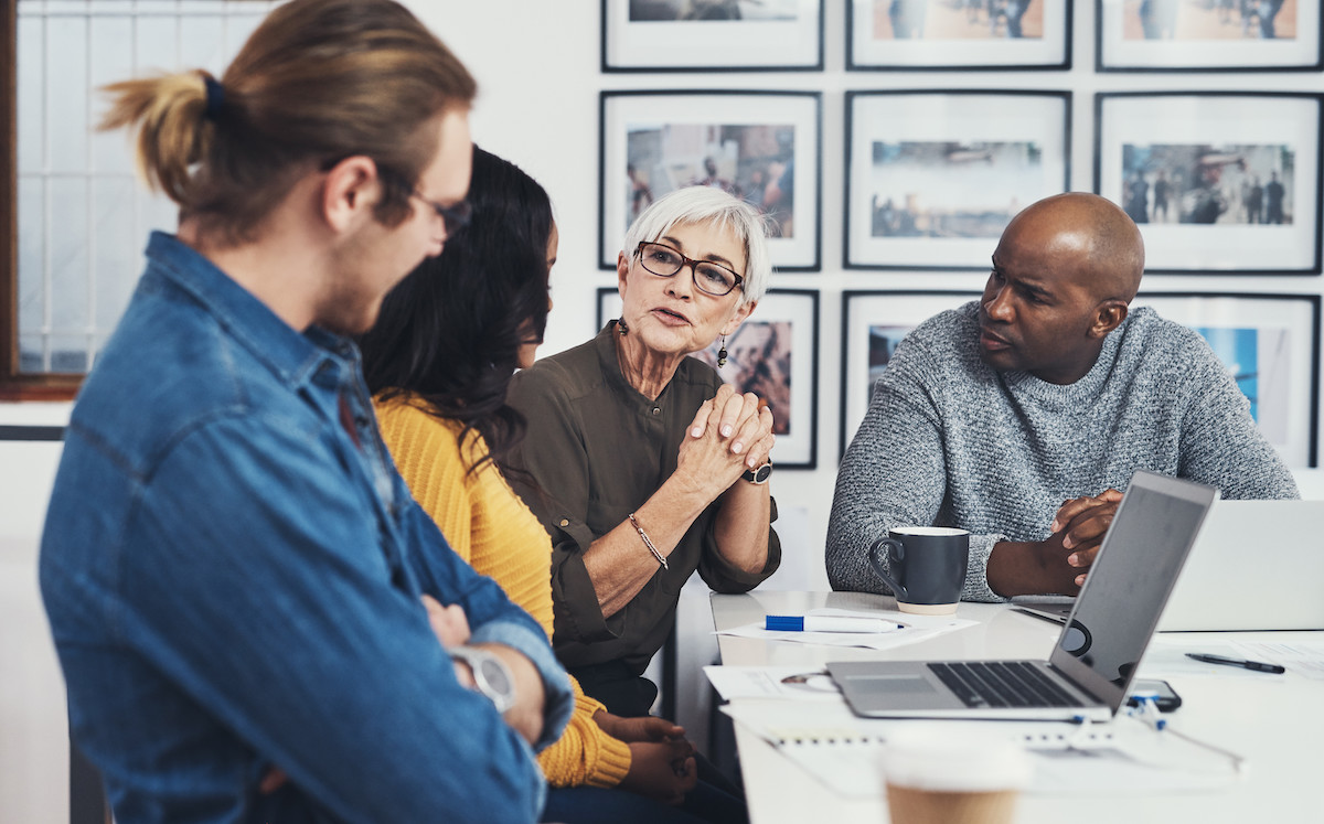 Group of confident businesspeople having a meeting together inside of the office during the day.